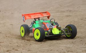 poglądowy zabawkowy, kolorowy samochodzik sterowany zdalnie jadący po piasku